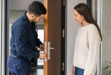 Profissional de chaveiro abrindo uma porta com ferramentas especializadas.
